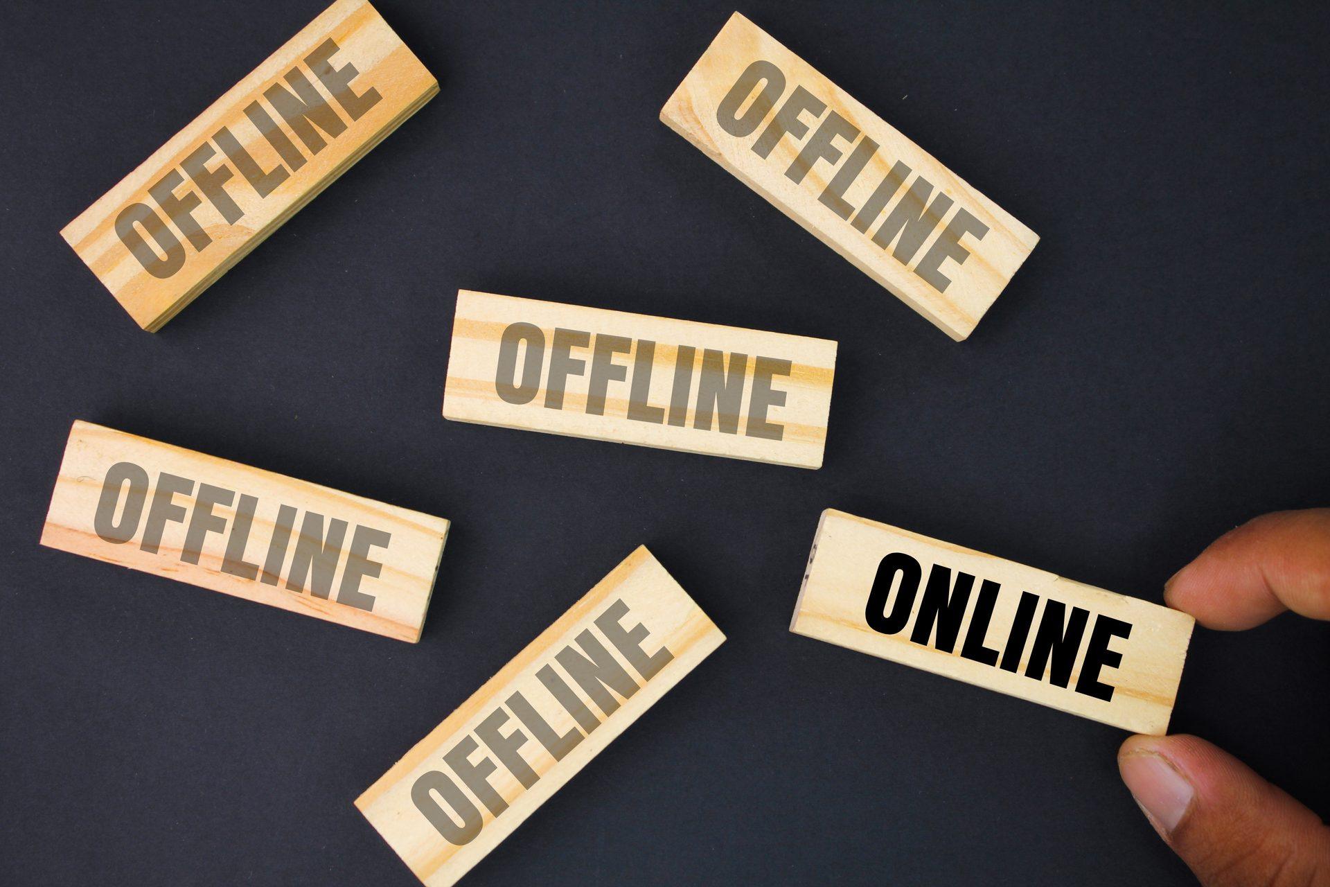 Palec naciska drewniany klocek z ikoną czasomierza i napisem OFFLINE